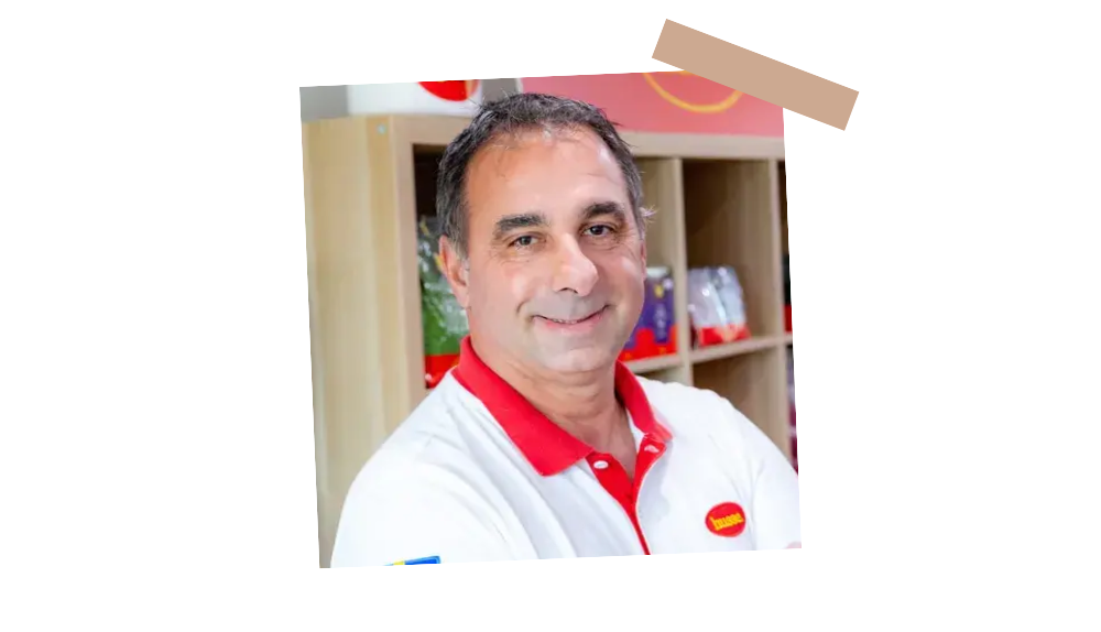 Thierry Bernard, franchisé Husse, souriant devant des étagères avec des produits Husse pour animaux de compagnie