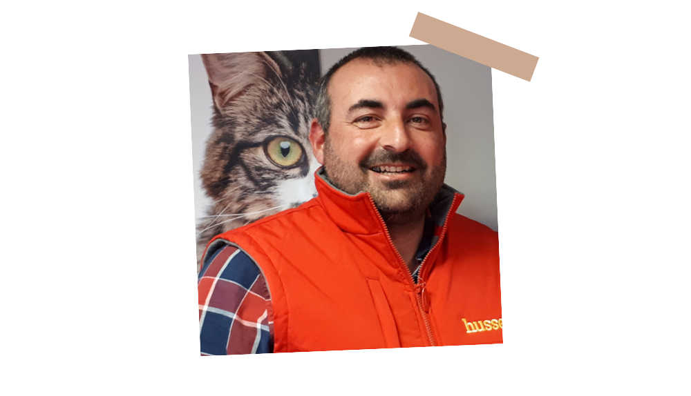 Fabien Amailland, franchisé Husse dans le 85, souriant devant une grande affiche de chat